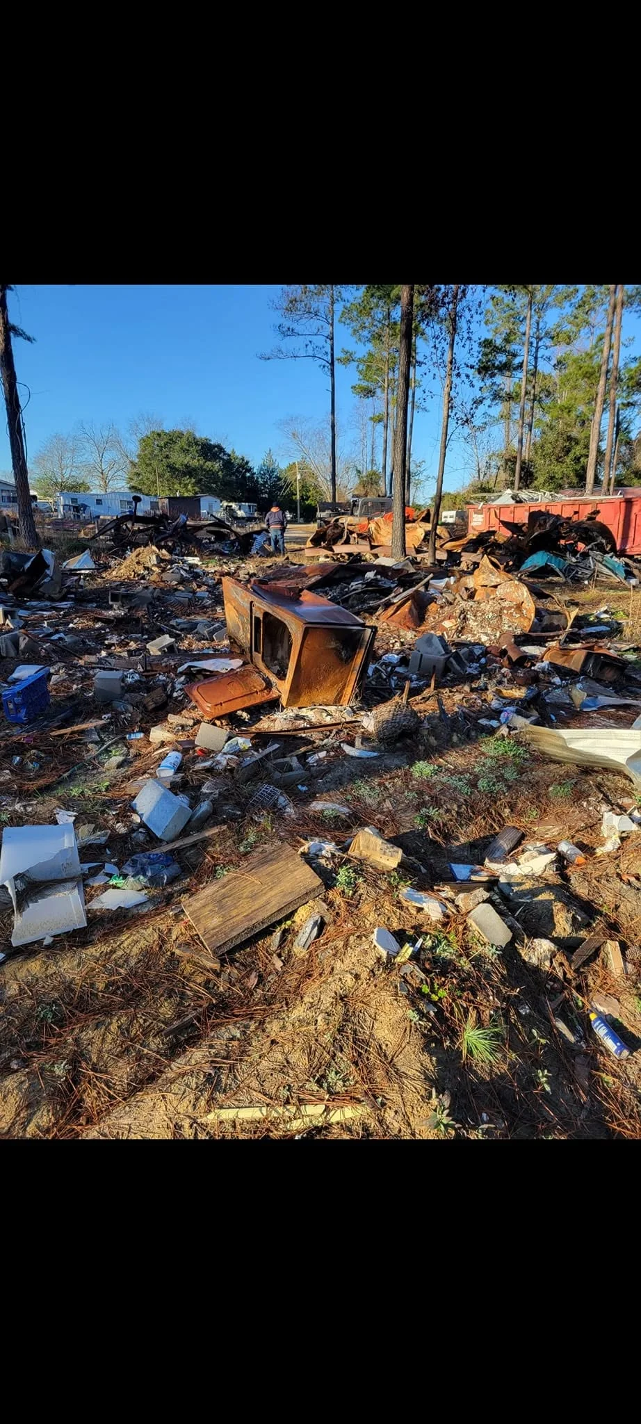 Overgrown lot with accumulated scrap metal, appliances, and debris before junk removal