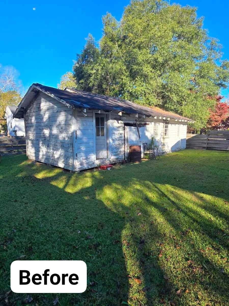 Weathered wood-frame outbuilding with blue siding before demolition removal